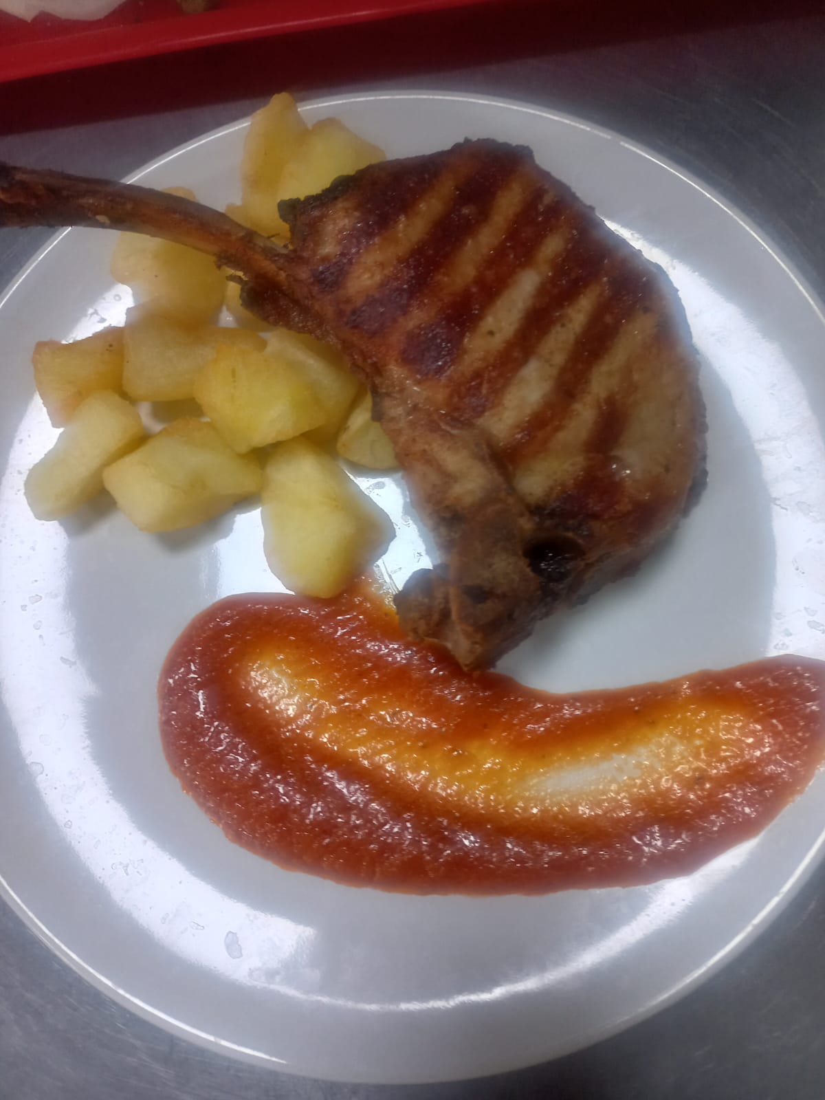 Tomahawk porc cu cartofi aurii și sos roșu